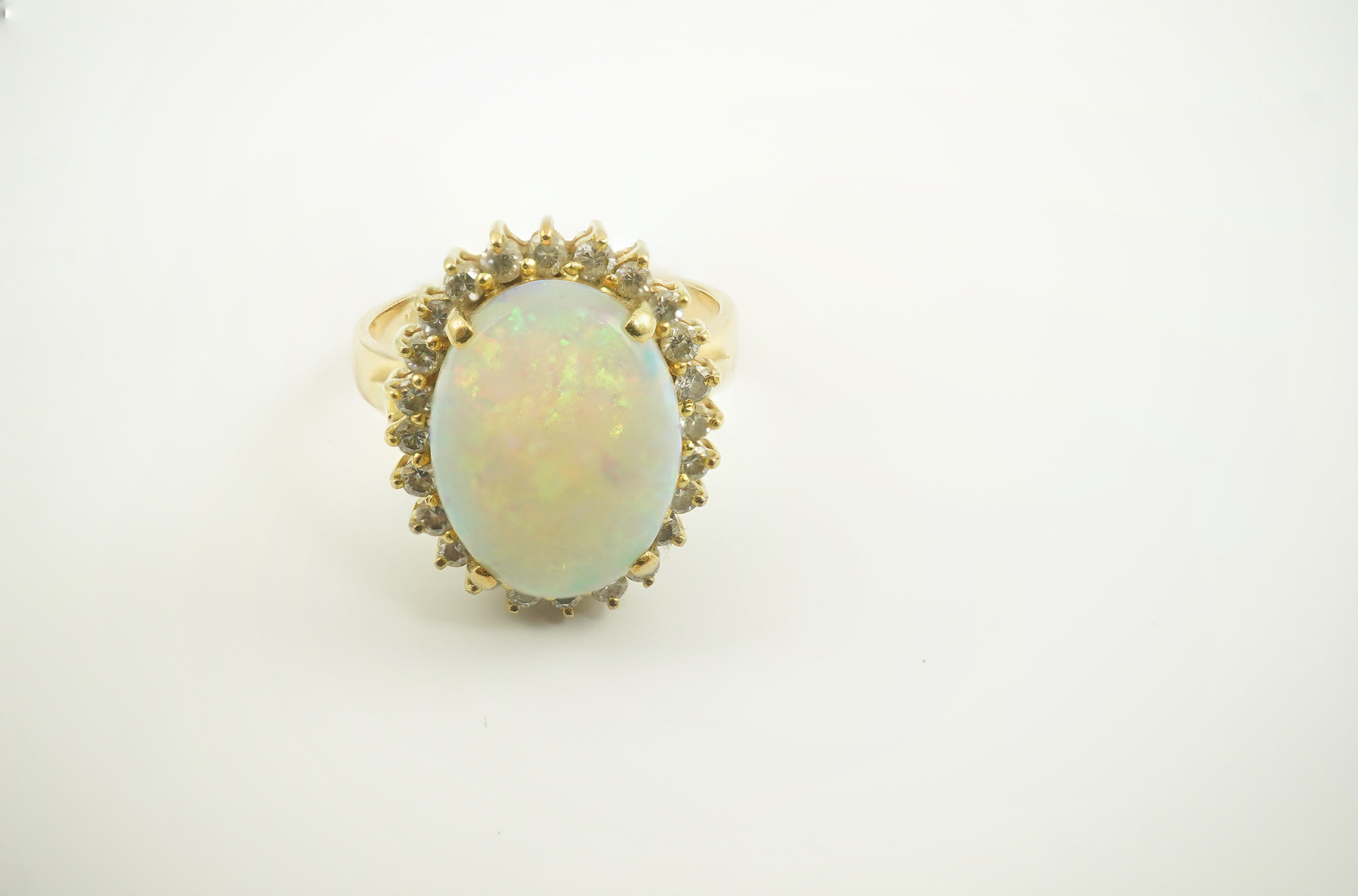 An 18k gold, white opal and diamond set oval cluster ring